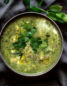 a bowl filled with green soup and garnished with parsley