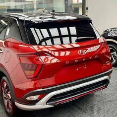 the rear end of a red car parked in a garage