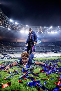 two football players laying on the ground surrounded by confetti