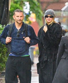 a man and woman walking down the street in the rain