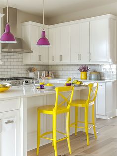 two yellow chairs sitting at a kitchen island