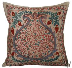 a decorative pillow with an ornate design on the front and back, sitting on a white surface