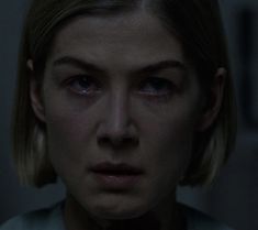 a close up of a person wearing a shirt and tie with blood on her face