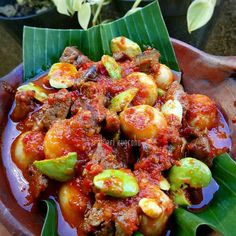 a bowl filled with food on top of a green leaf