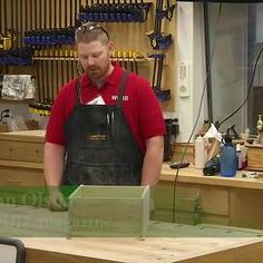 a man is working in a shop with tools on the table and behind him he is wearing an apron