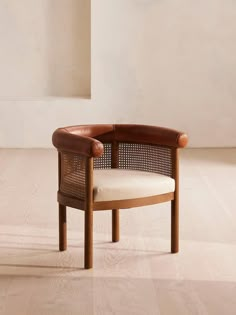 a wooden chair sitting on top of a hard wood floor next to a white wall