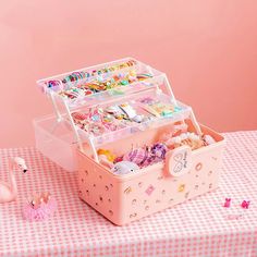 a pink box filled with lots of toys on top of a table