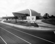 a black and white photo of an empty road with a large building in the background