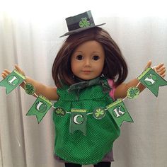 a doll is dressed in green and holding her hands up to the side with shamrocks on it