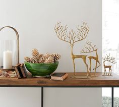 a wooden table topped with christmas decorations and deer figurines on top of it