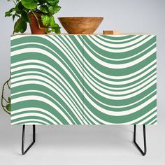 a green and white cabinet sitting next to a potted plant on top of it