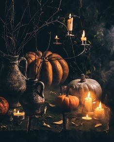 pumpkins and candles are sitting on the table