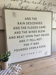 a wooden sign that says and the rain descended and the floods came and beat upon that house and it fell not for it was found upon a rock