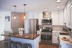 an image of a kitchen setting with stainless steel appliances and wood counter tops in the foreground