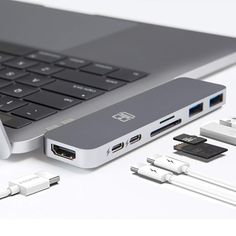 an open laptop computer sitting on top of a white table next to other electronic devices