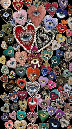 an assortment of heart shaped brooches with eyeballs and hearts on them, all in different colors