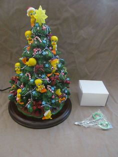 a small christmas tree sitting on top of a wooden table next to a white box