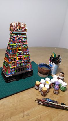 there is a small tower made out of paint bottles and other items on the table