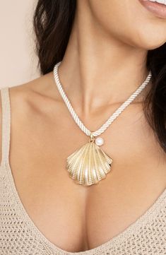 A gleaming shell pendant anchors the ropy cord of this sea-inspired necklace sure to make a statement. 15" length; 5" extender Lobster clasp closure 18k-gold plate/textile/imitation pearl Imported Ettika Jewelry, Gold Body Chain, Seashell Pendants, Scallop Shell, Scallop Shells, Silk Cord, Pearl Charms, Freshwater Cultured Pearls, Beach Inspired