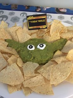 a plate topped with chips and guacamole covered in googly eyeballs