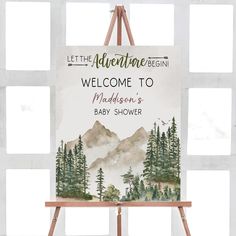 a welcome sign is on an easel in front of a window that reads, let the adventure begin