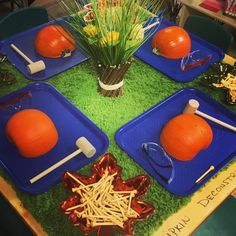 four blue trays filled with food sitting on top of a green table covered in grass