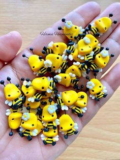 small yellow and black bees with white flowers on their heads are held in someone's hand