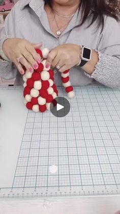 a woman is making an ornament out of felt and yarns on a sewing machine