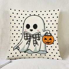 a pillow with a ghost holding a pumpkin