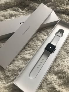 an apple watch is in its box on the floor next to it's packaging