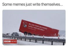 a big red truck driving down a snow covered road next to traffic cones and trees