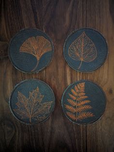 four coasters with leaf designs on them