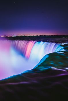 the niagara falls at night lit up with colorful lights and water cascadings