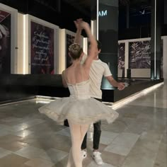 a man and woman are dancing on the dancefloor in front of some posters