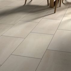 a table and chairs in a room with tile flooring that looks like it has been made out of wood