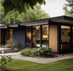 a black and brown house with lots of windows in the front yard, surrounded by green grass