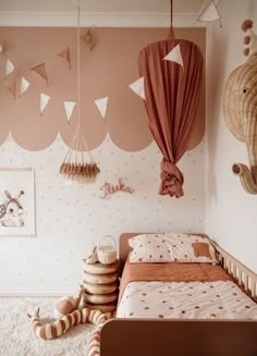 a child's bedroom decorated in pink and white with lots of hanging decorations on the wall