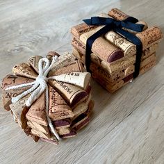 two wine corks wrapped in black ribbon sitting on a wooden floor next to each other