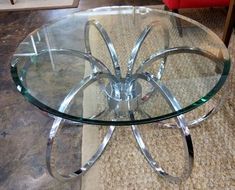 a glass table with metal legs on carpeted floor