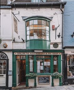 the outside of a restaurant and pet shop on a street corner in an old town