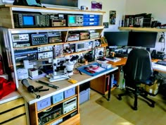 an office with many electronic equipment on the desk