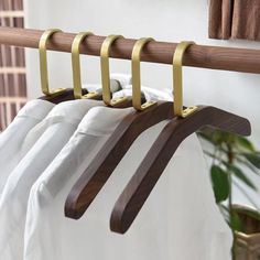 three wooden clothes hangers hanging on a rail