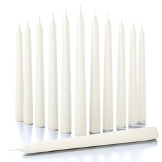 several white candles lined up next to each other with one candle sticking out from the middle