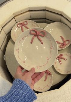 a person holding plates with pink bows on them