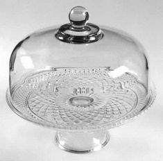 a glass covered dish with a domed lid