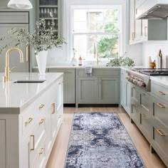 a kitchen with white cabinets and an area rug on the floor