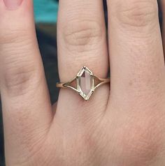 a close up of a person's hand with a gold ring on top of it