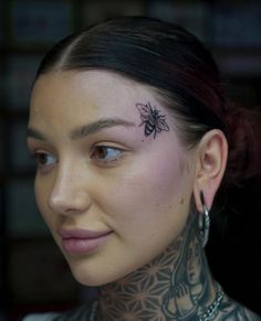 a woman with tattoos on her neck looking at the camera