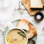 a bowl of soup with bread on the side