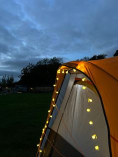 a tent is lit up with fairy lights